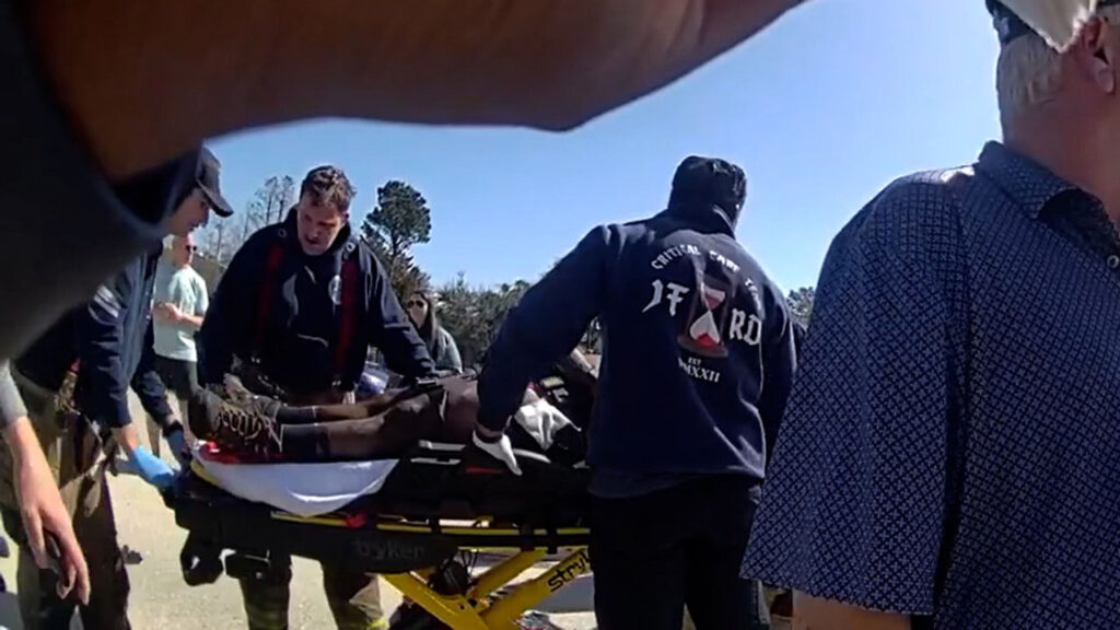 paramedics pushing accident victim on a stretcher on the highway